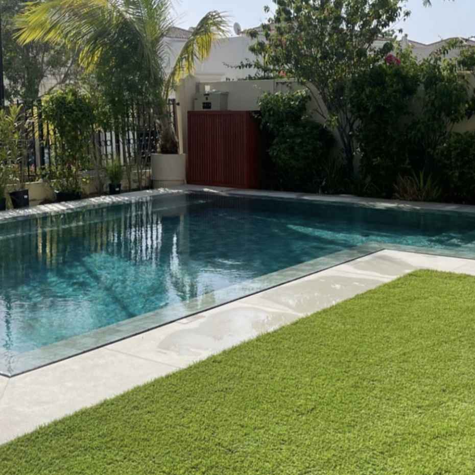 Stunning Swimming Pool with Alpine Green 100x100 Mosaic Pool Tile, Enhanced by an Outdoor Floor of Artificial Grass, Beautifying the Outdoor Space