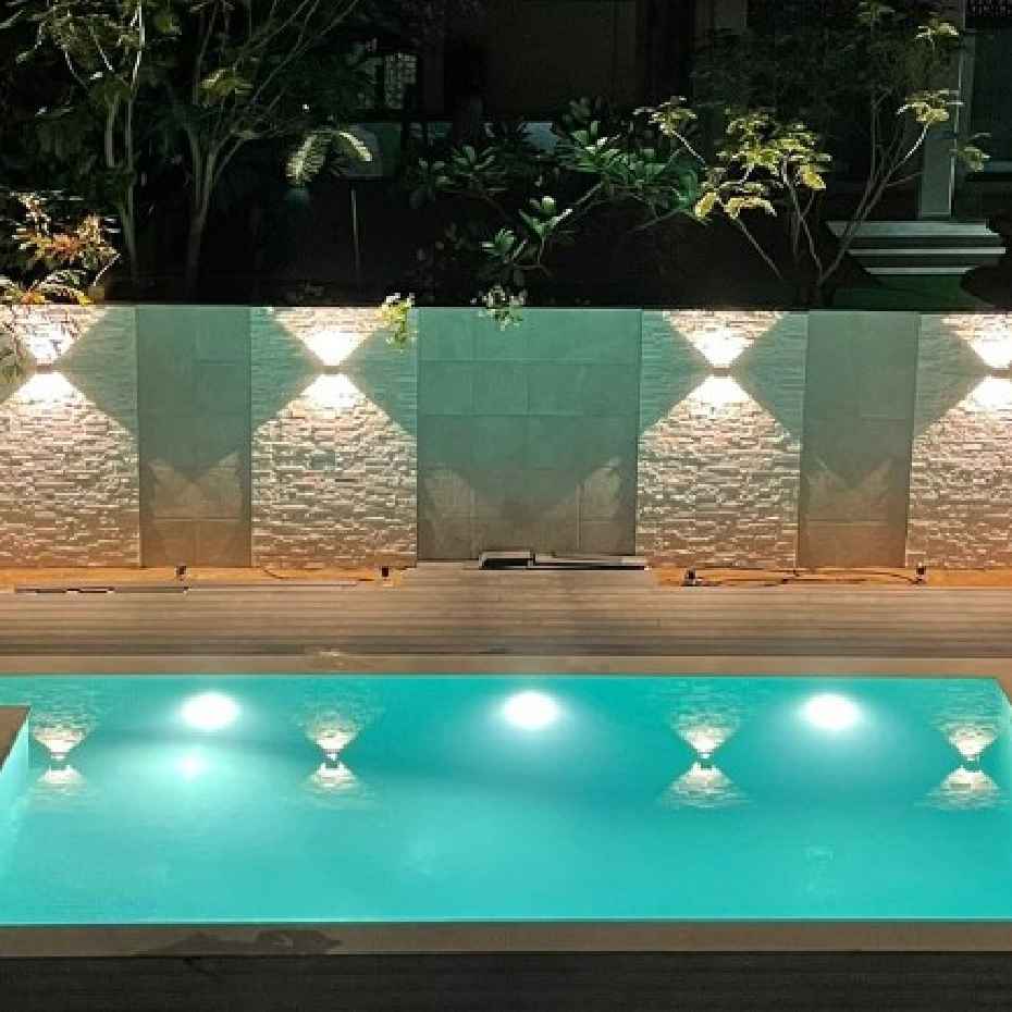 Side View Of A Pool With 201 Light Green Glass Mosaic Pool Tile, Reflecting Wall Lights.