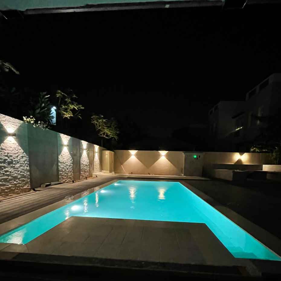 Night View Of A Swimming Pool With EGM-201 Light Green Glass Mosaic Swimming Pool Tile.