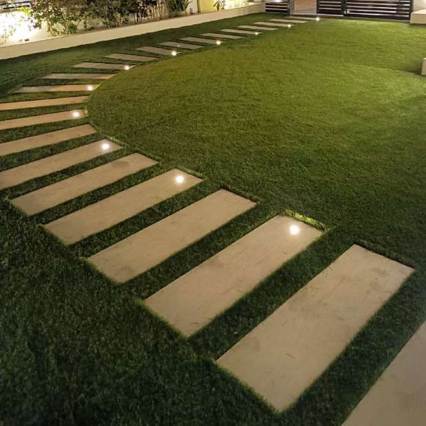 nhanced Outdoor Space of a Villa with Artificial Grass and Tiled Pavement, Creating an Adorable Look | Elixir - The Premier Choice for Synthetic Grass in Dubai.