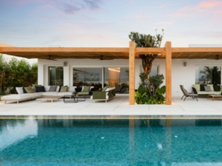 Swimming pool enhanced with mosaic pool tiles in front of a beautiful house.