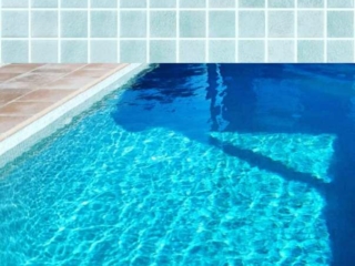Swimming pool with Elixir pool tiles, imparting a beautiful blue hue to the water.