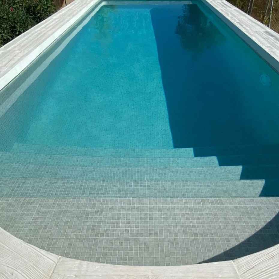Front View Of A Beautiful Swimming Pool With 5 Steps Featuring EGM-Seal Glass Mosaic Pool Tile