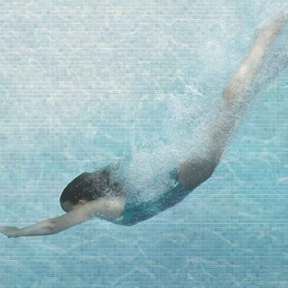 A Girl Diving Down In A Swimming Pool Made Of EGM-Pearl 500 Mosaic Pool Tiles