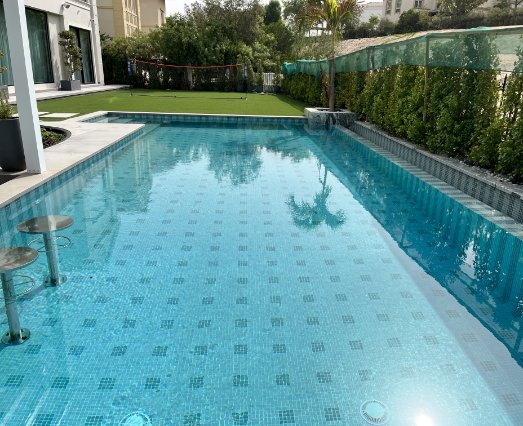 Swimming Pool Made Of Mosaic Pool Tile, Next To It Is A Small Shuttle Ground Made Of Fake Grass