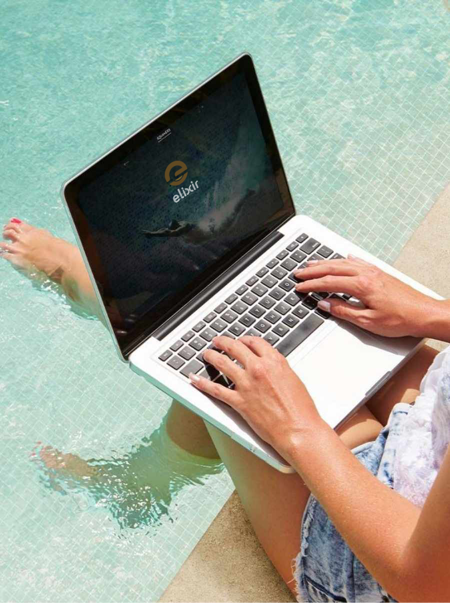 A Woman Sitting By The Swimming Pool Side  With A Laptop On Her Lap, Featuring The Elixir Logo