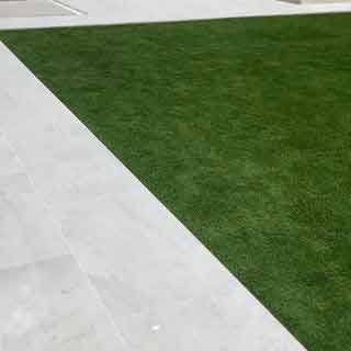 Fake grass installed alongside outdoor tiles