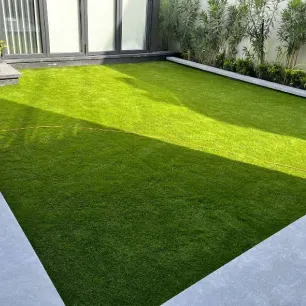 An backyard adorned with a lush artificial grass carpet.