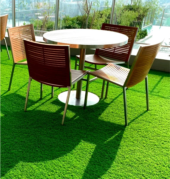 A table and chairs positioned on a green fake grass carpet