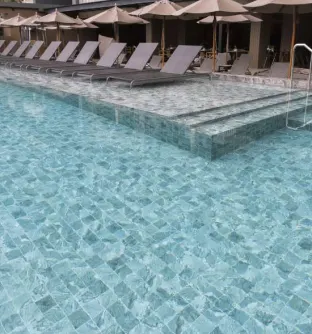 Dubai poolside loungers and steps covered in porcelain surfaces designed with non-slip swimming pool tile.
